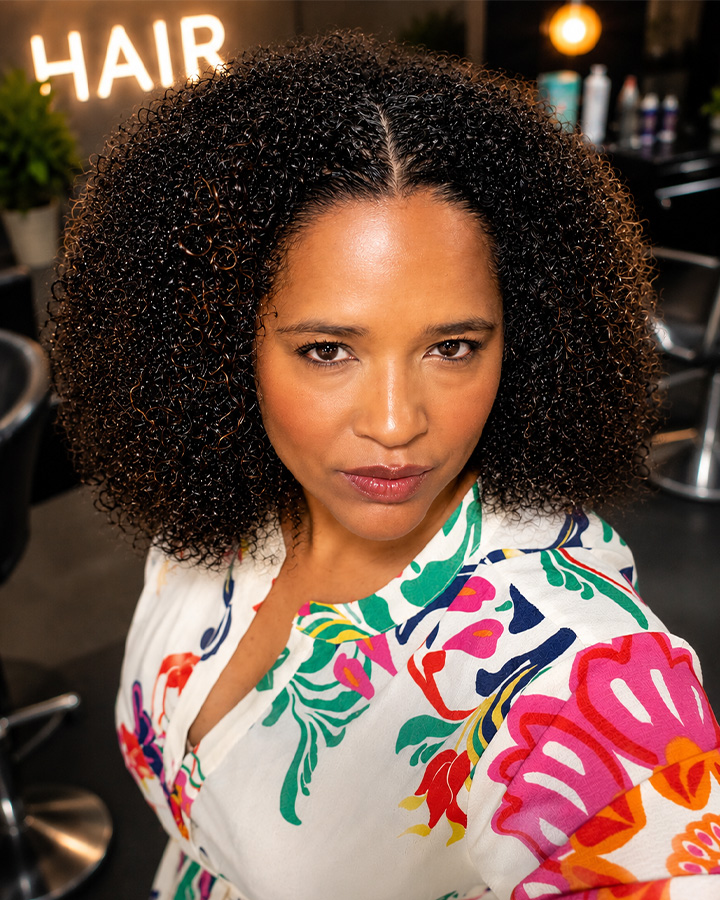 Leandra Roch'e, founder and Master Stylist of HD Hair Design, holding a hair bundle in her Merrillville salon
